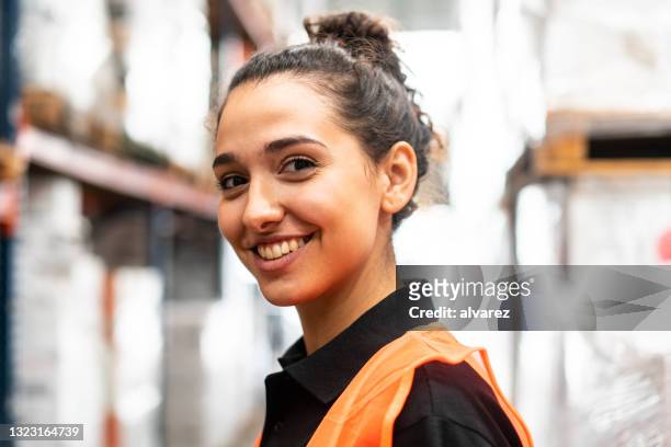 close-up of a happy woman working in warehouse - employee of the month stockfoto's en -beelden