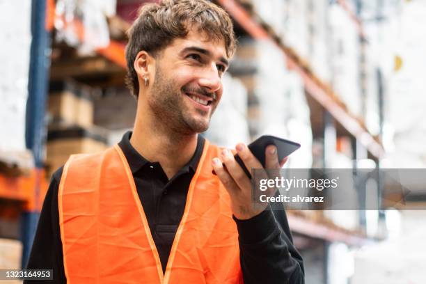 warehouse worker using mobile phone at work - conference phone stock pictures, royalty-free photos & images