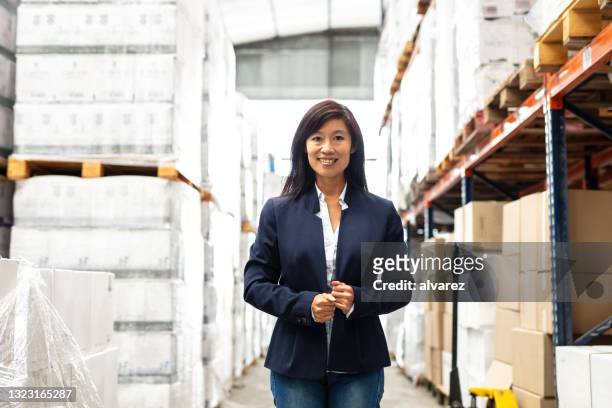 porträt einer erfolgreichen geschäftsfrau im fabriklager - baumarkt mitarbeiter stock-fotos und bilder