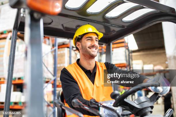 warehouse worker operating a forklift - chauffeur beroep stockfoto's en -beelden