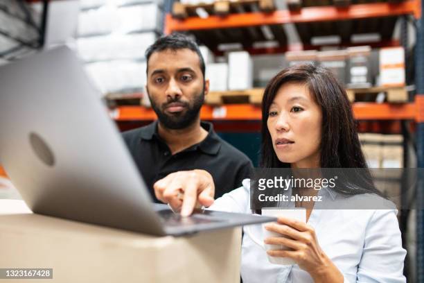 personal de almacén trabajando en una computadora portátil - hardware store fotografías e imágenes de stock