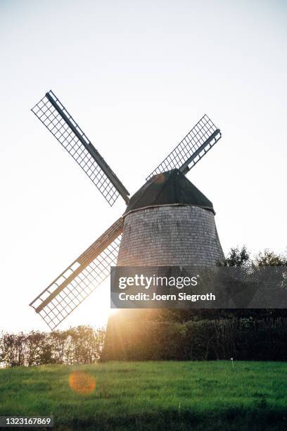 windmühle bei sonnenuntergang - soziales thema stock pictures, royalty-free photos & images