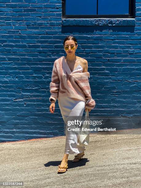 Julia Comil wears a silk satin cami top in off white by Dorothee Schumacher, a silk satin skirt neutral off white by Dorothee Schumacher, a graphic...