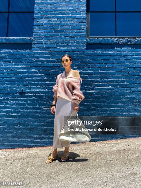 Julia Comil wears a silk satin cami top in off white by Dorothee Schumacher, a silk satin skirt neutral off white by Dorothee Schumacher, a graphic...