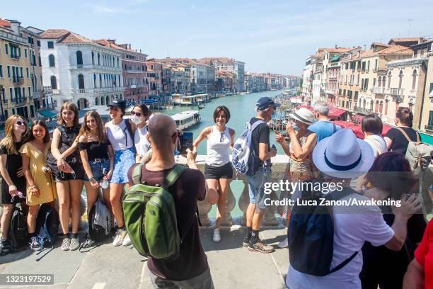 Tourists take a smartphone photograph on Rialto bridge on June 12, 2021 in Venice, Italy. International tourists started to travel again after the...