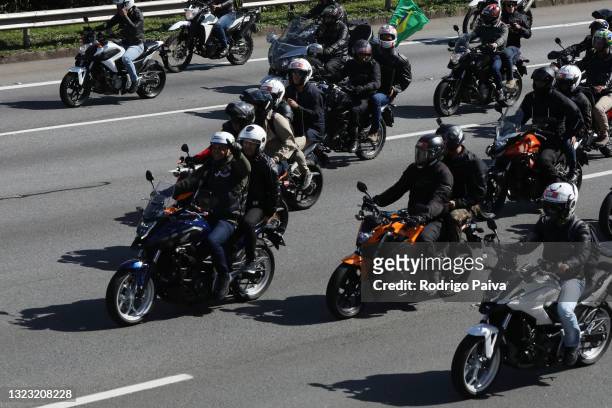 President of Brazil Jair Bolsonaro rides a motorcycle followed by supporters during a motorcycle rally through Rodovia dos Bandeirantes on June 12,...
