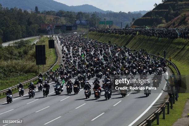 President of Brazil Jair Bolsonaro rides a motorcycle as he leads supporters during a motorcycle rally through Rodovia dos Bandeirantes of Sao Paulo...