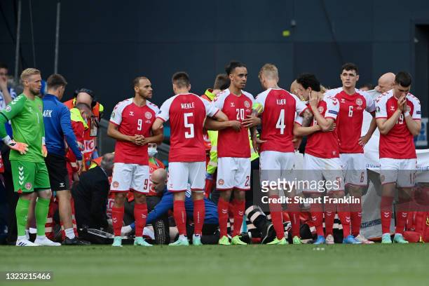 Denmark players surround Christian Eriksen of Denmark as he receives medical treatment during the UEFA Euro 2020 Championship Group B match between...