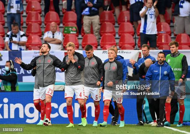 Pierre-Emile Hojbjerg, Simon Kjaer, Joakim Maehle and Daniel Wass of Denmark enter the pitch for the warm up before play resumes during the UEFA Euro...