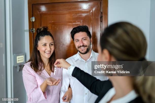 new home owners receiving the keys to a new apartment - landlord stock pictures, royalty-free photos & images