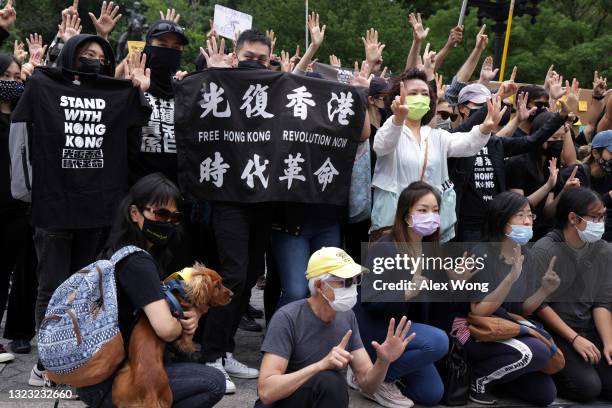 Hong Kongers gesture the "Five demands, not one less" protest motto as they gather during a rally at Union Square to support Hong Kong June 12, 2021...