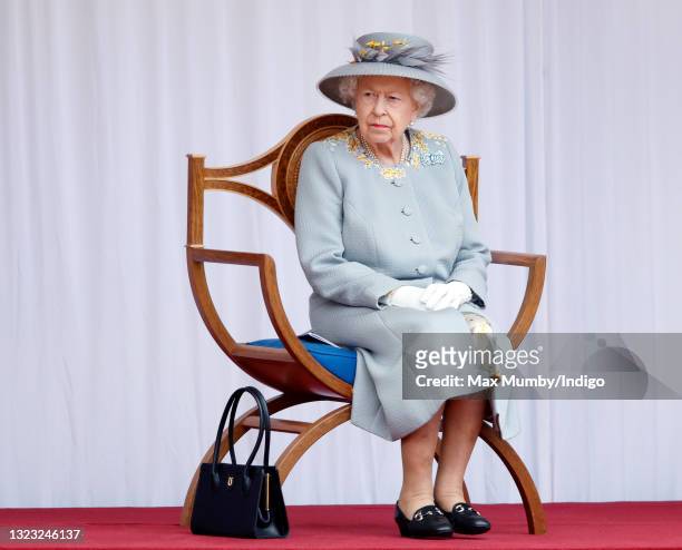 Queen Elizabeth II attends a military parade, held by the Household Division in the Quadrangle of Windsor Castle, to mark her Official Birthday on...