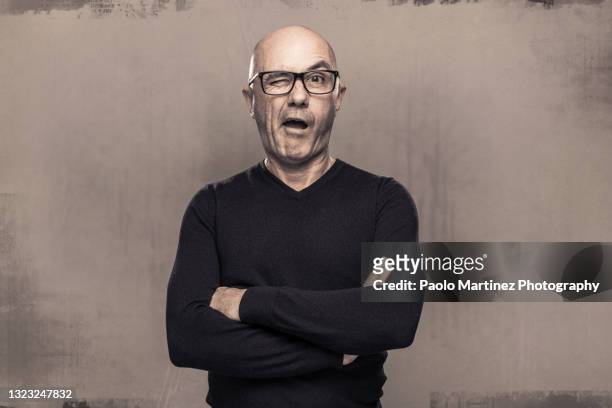 middle aged man wearing a black shirt winking at the camera - ironia imagens e fotografias de stock