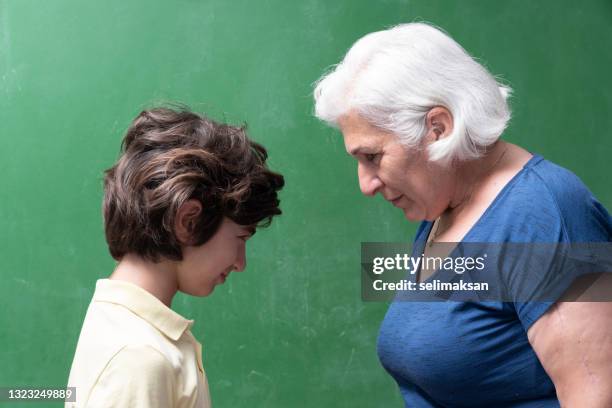 portrait of stubborn senior woman with white hair and grandson confronting - confrontation stockfoto's en -beelden