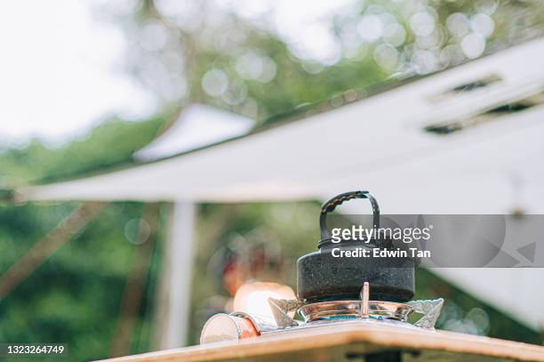 朝のピクニックテーブルで沸騰するキャンプストーブホットケトル - ガス台 ストックフォトと画像