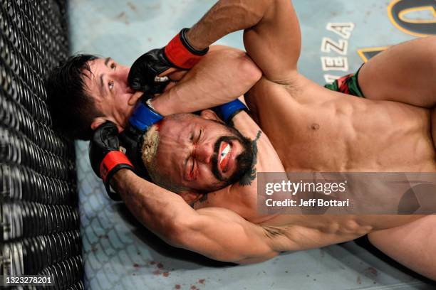 Brandon Moreno of Mexico secures a rear choke submission against Deiveson Figueiredo of Brazil in their UFC flyweight championship fight during the...