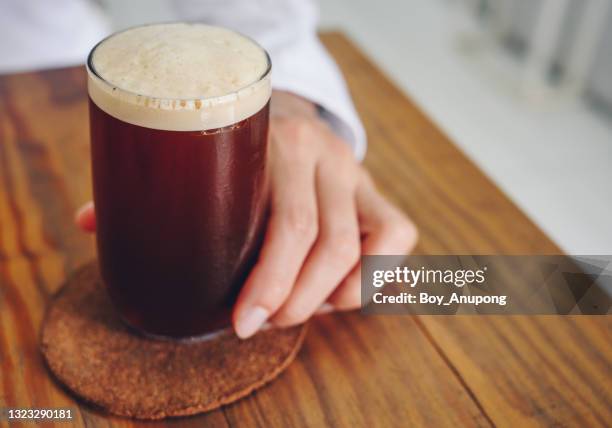 a nitro cold brew coffee on the wood table in cafe shop. - portier stockfoto's en -beelden