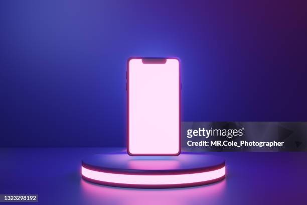 3d rendered smart phone on the stage with neon colored tone - fluorescente - fotografias e filmes do acervo