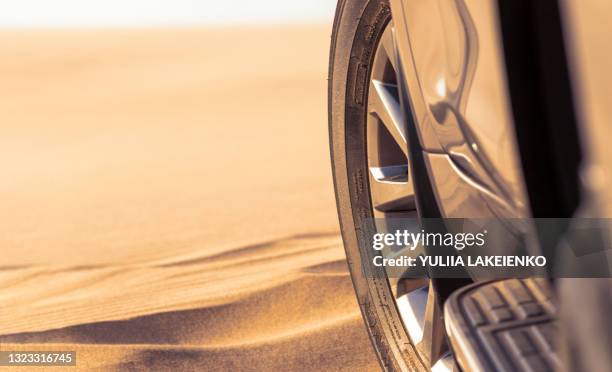 Close up of a golden car stuck in the sand in the Namib desert.