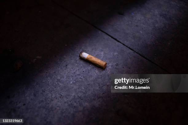 colilla de cigarro en la acera, rayo luz - stubs stock pictures, royalty-free photos & images