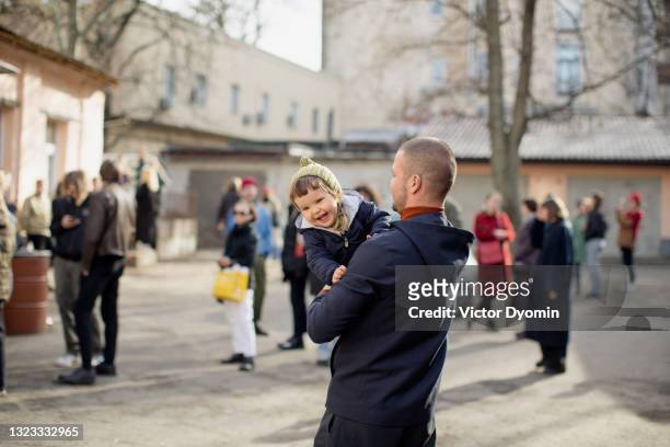 young man holds his little laughing daughter - ukraine city stock pictures, royalty-free photos & images