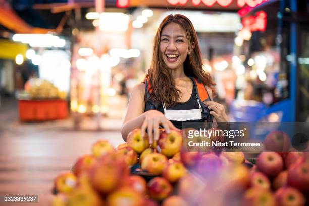 young asian women enjoying late night food and shopping in one of the bangkok's chinatown street markets. - bazaar market stockfoto's en -beelden