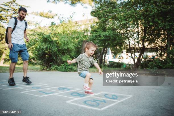 father and son playing hopscotch - hopscotch stock pictures, royalty-free photos & images