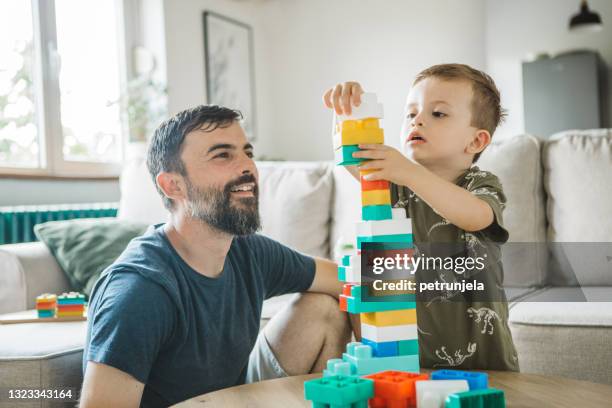 vater und sohn zu hause - wooden blocks stock-fotos und bilder