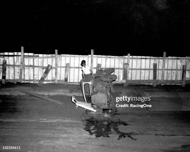 Driver climbs out the window of his Modified stock car following a rollover crash at Greensboro Fairgrounds.