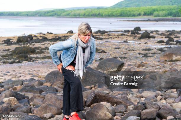an active mature woman with hip pain - hip stock pictures, royalty-free photos & images