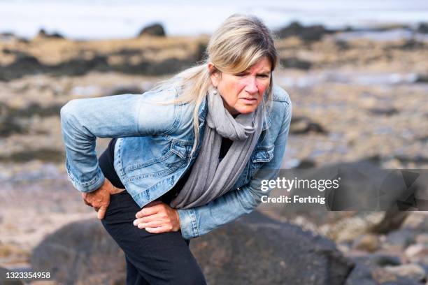 eine aktive reife frau mit hüftschmerzen - hüfte stock-fotos und bilder