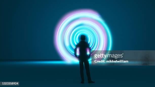 el hombre se para frente a un vórtice o máquina del tiempo con un patrón espiral - innovacion fotografías e imágenes de stock