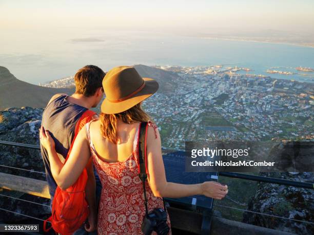 vue arrière d’un jeune couple de touristes regardant la ville du cap depuis le sommet de la montagne de la table - southern africa photos et images de collection