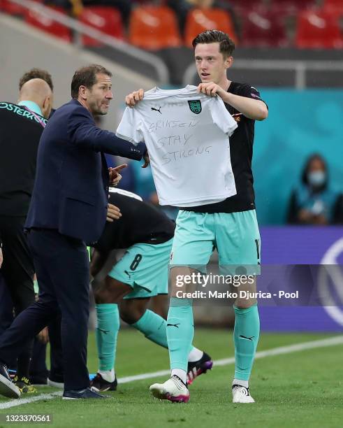 Michael Gregoritsch of Austria celebrates after scoring their side's second goal as he holds a t-shirt with a message of support for Christian...