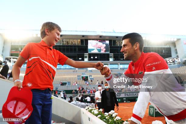 Tournament winner Novak Djokovic of Serbia celebrates with a young fan after winning his Men's Singles Final match against Stefanos Tsitsipas of...