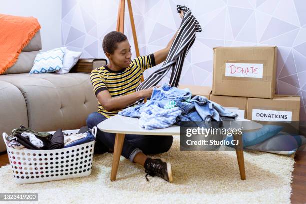 woman unloading donation items for selection - clothing donations stock pictures, royalty-free photos & images