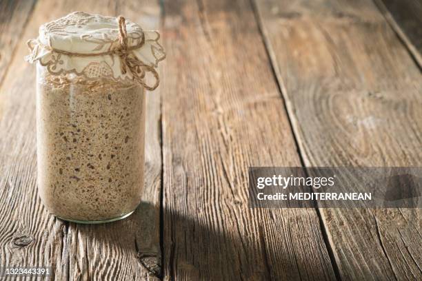 arrancador de masa madre para pan y agente leudante de panadería levain en mesa de madera rústica - levadura fotografías e imágenes de stock