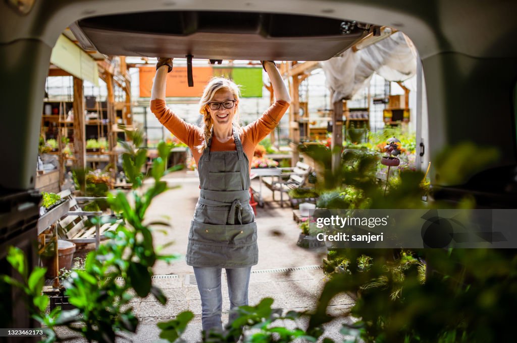 Garden Center Worker Transporting Plants