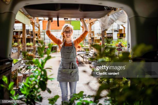 garden center worker transporting plants - car exports imagens e fotografias de stock