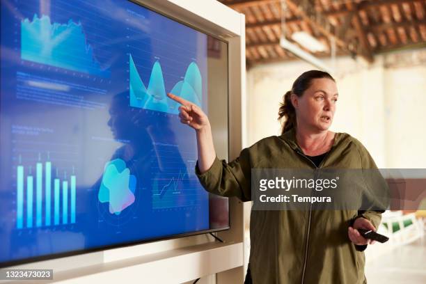 a businesswoman making a presentation speech. - mature woman screen stock pictures, royalty-free photos & images