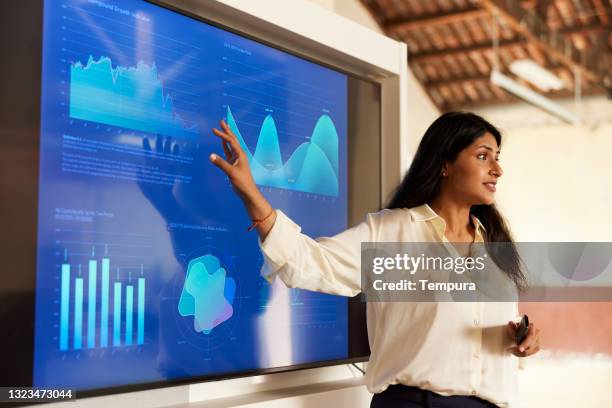 une femme d’affaires partageant des graphiques dans un discours de présentation. - présentation photos et images de collection