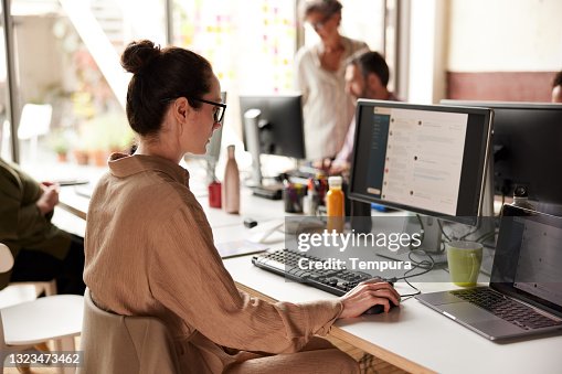 Eine Geschäftsfrau, die E-Mails in einem Büro sendet. Eine Geschäftsfrau, die E-Mails in einem Büro sendet.