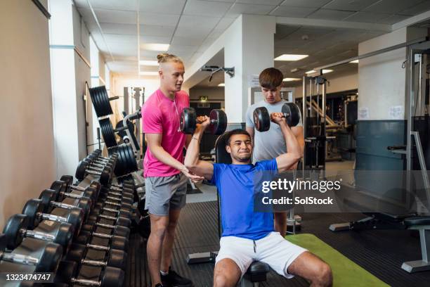 young men weight training - spotting bildbanksfoton och bilder