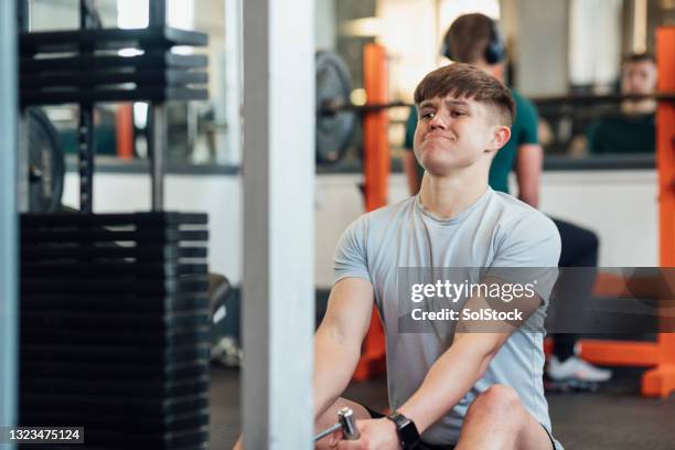 seated rows in the gym - aparelho de musculação imagens e fotografias de stock
