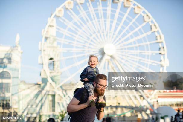 father and son near the white ferris wheel - famous family funfair stockfoto's en -beelden