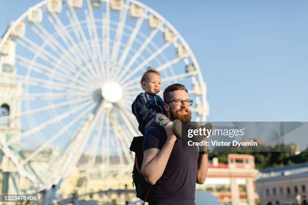 young father and his little son look away together - parque de diversões edifício de entretenimento - fotografias e filmes do acervo