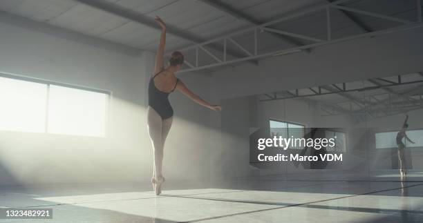 rearview shot of an unrecognizable young woman practicing ballet in a dance studio - dancing studio shot stock pictures, royalty-free photos & images
