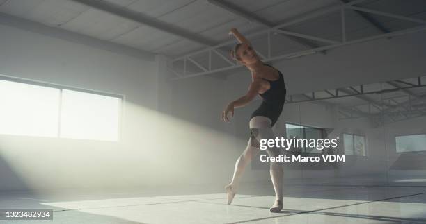 full length shot of an attractive young woman practicing ballet in a dance studio - dancing studio shot stock pictures, royalty-free photos & images