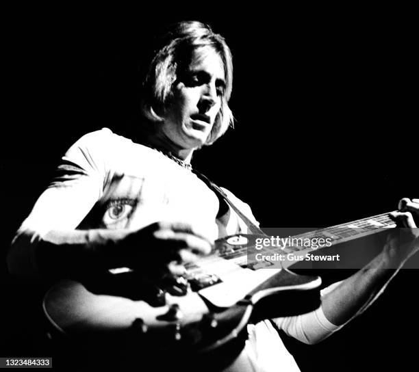 Mick Ronson of the Hunter Ronson Band performs on stage at Hammersmith Odeon, London, England, on April 12th, 1975. He is playing a Gibson Les Paul...