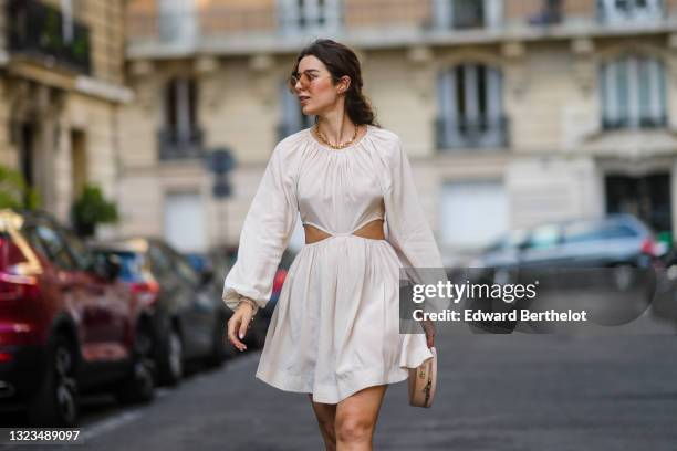 Ketevan Giorgadze @katie.one wears oversized sunglasses by For Art’s Sake, a gold chain necklace by For Art’s Sake, a white cut out mini dress with...